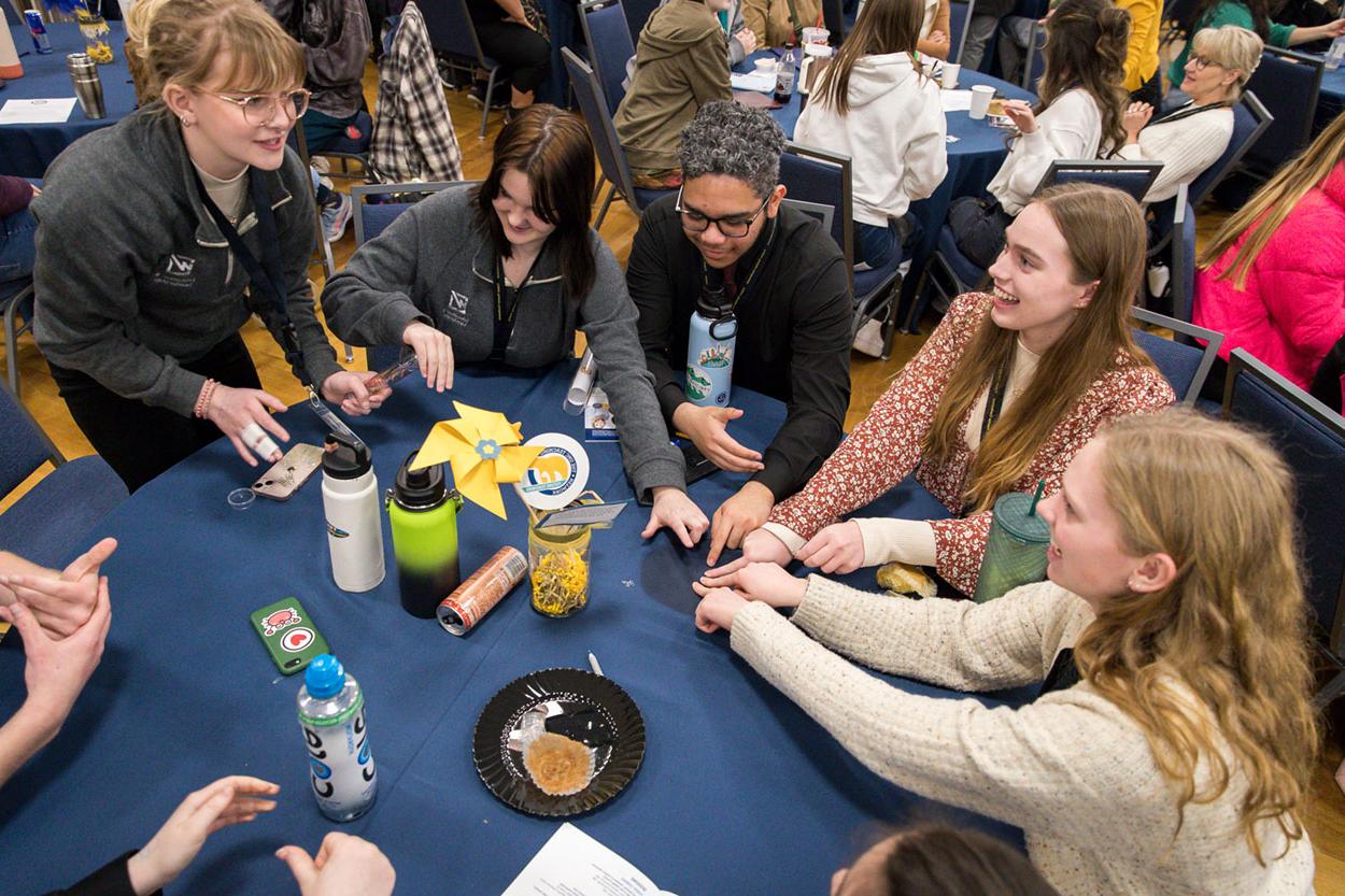 Group of students at a round table playing a game.